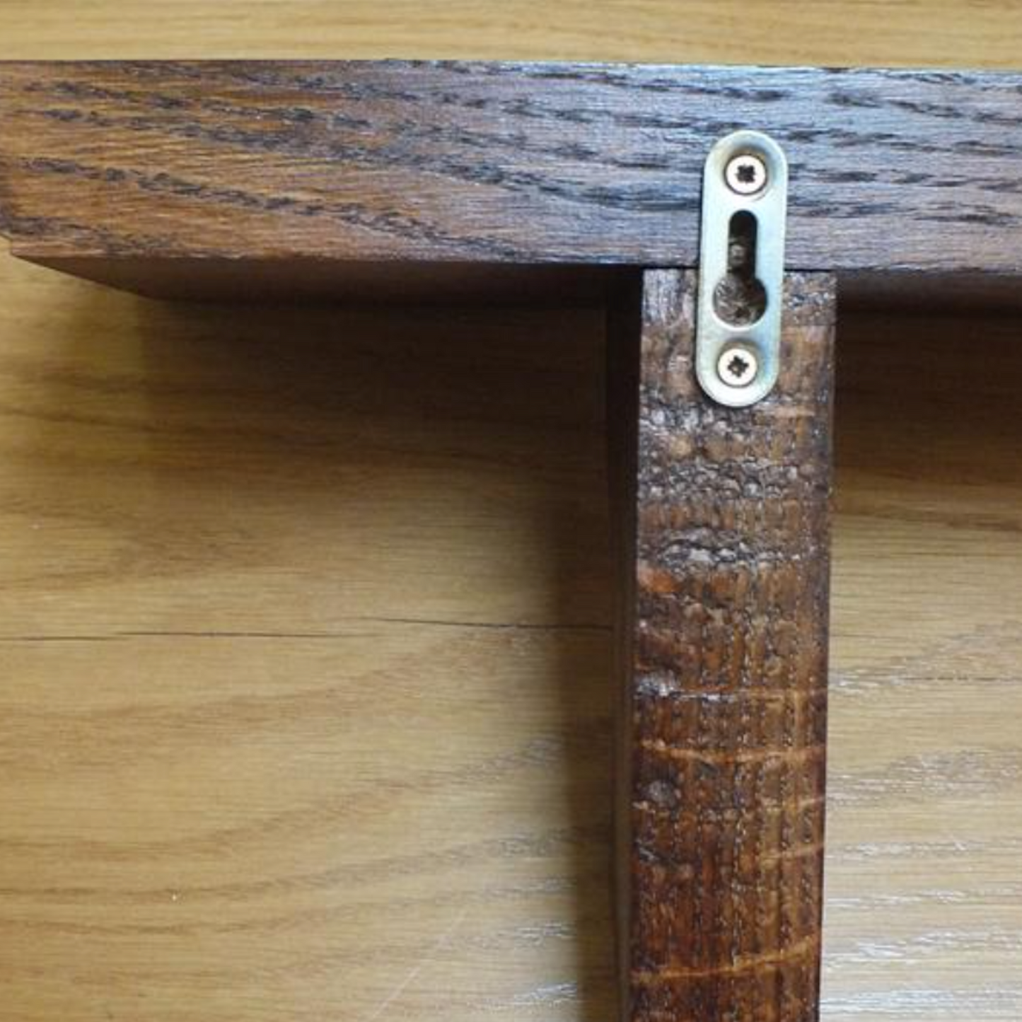 Wooden shelf with a metal bracket on a wooden surface