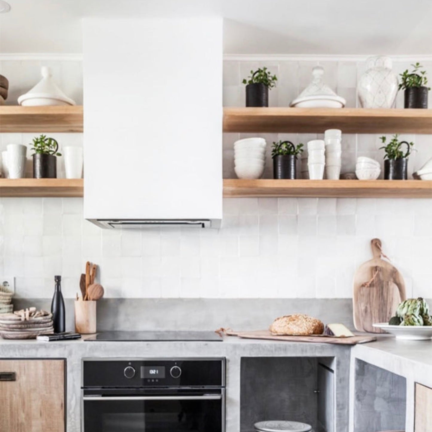 Modern kitchen with concrete countertops and wooden shelves.