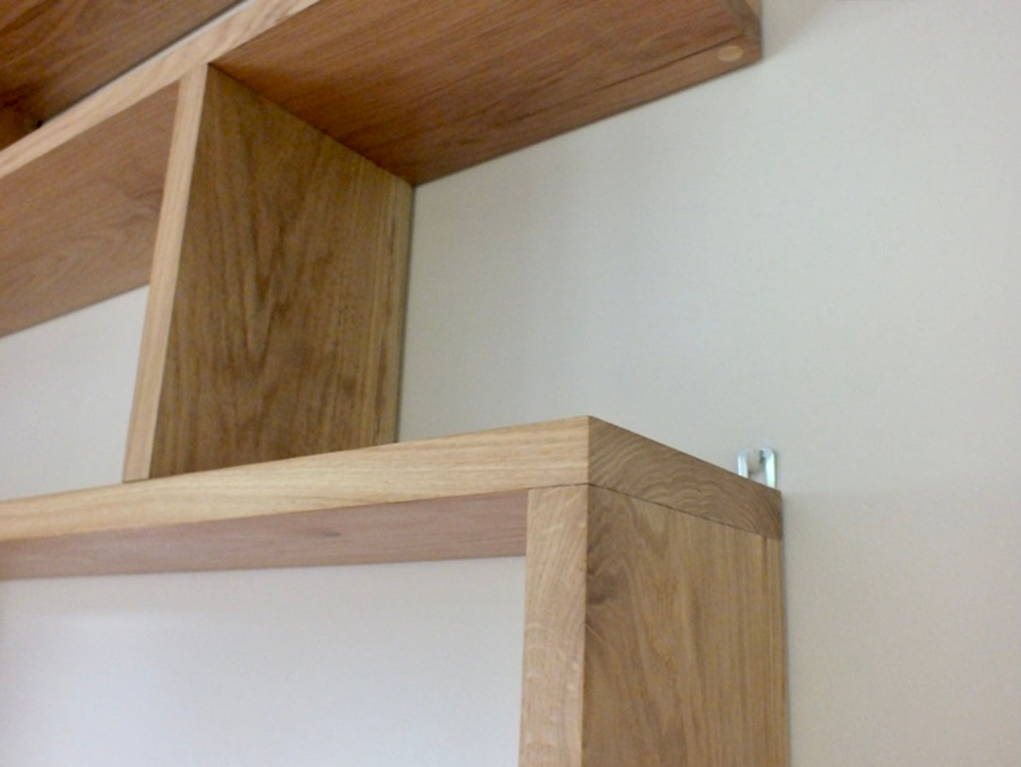Wooden shelf brackets against a plain wall