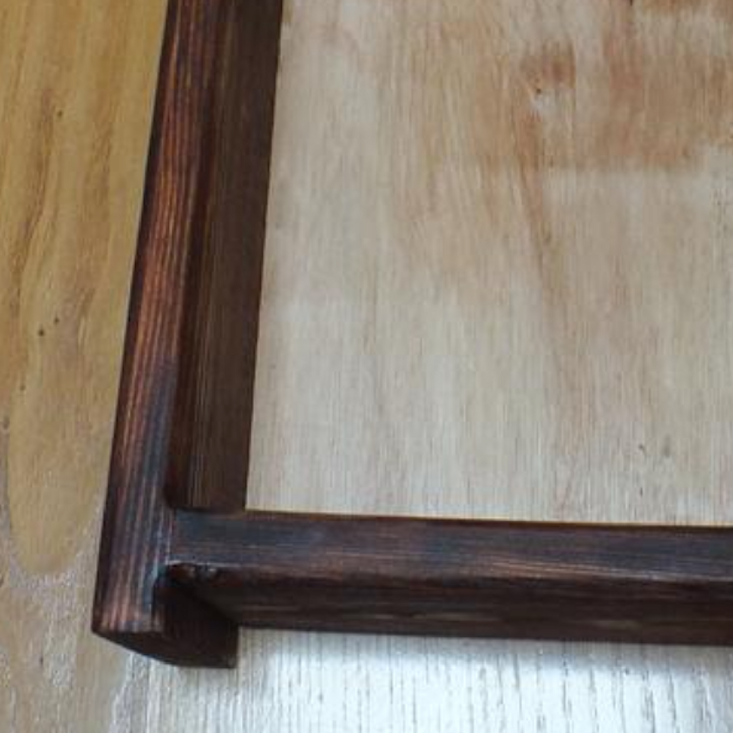 Wooden frame with a light wooden interior on a wooden surface