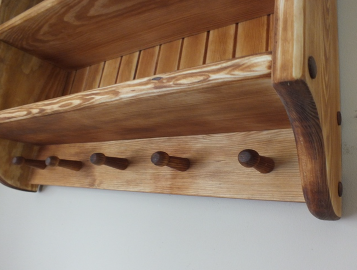S92 Schrank im Landhausstil aus massivem Holz mit gewellter oberer Leiste und Stiften