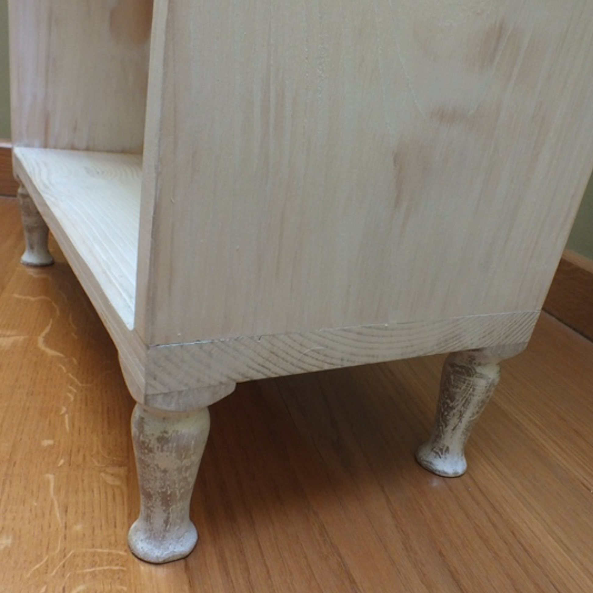 Wooden cabinet with legs on a wooden floor