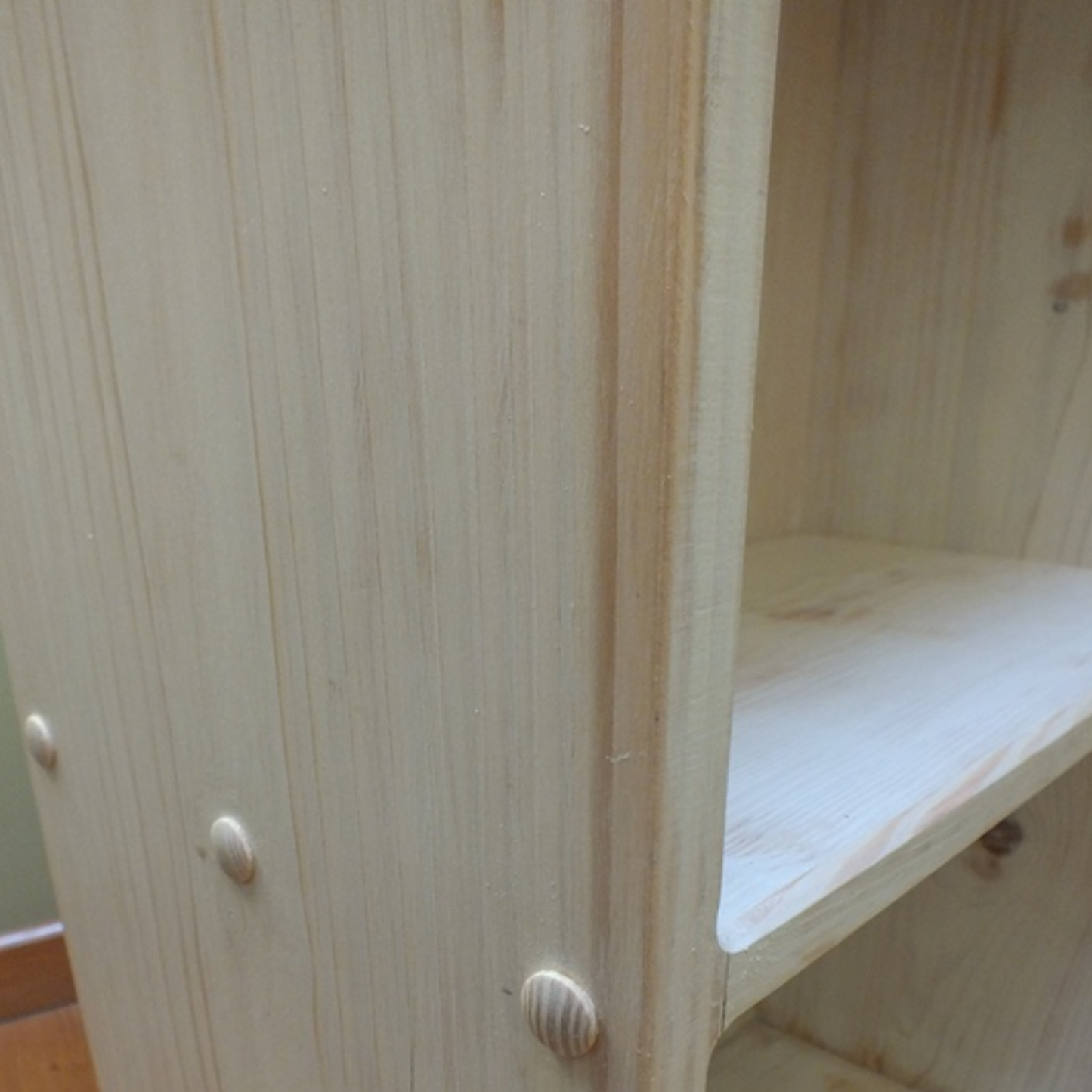 Wooden shelf with two shelves on a wooden floor.