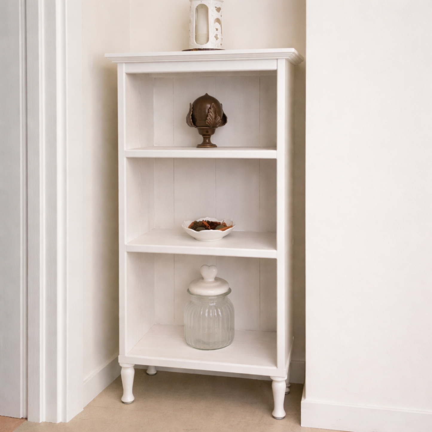 White bookshelf with decorative items against a white wall