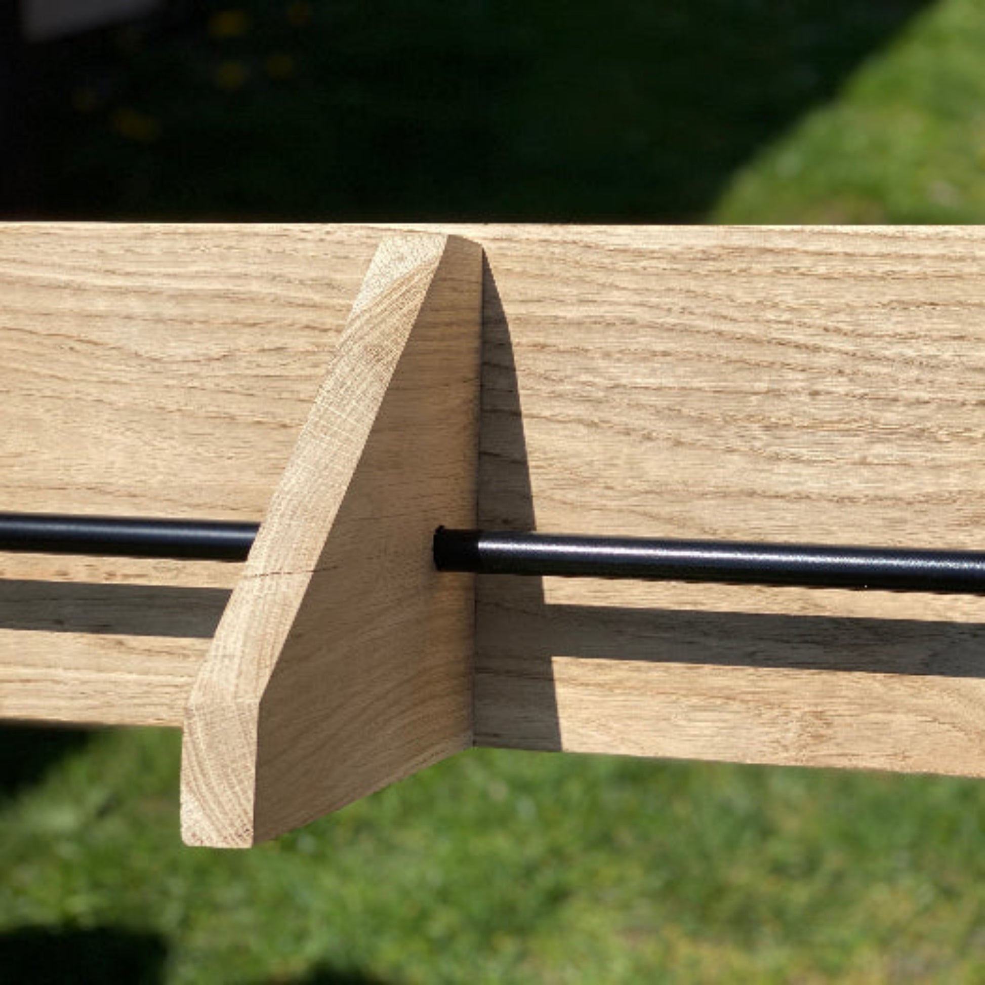 Wooden bench with metal armrests on a grassy background