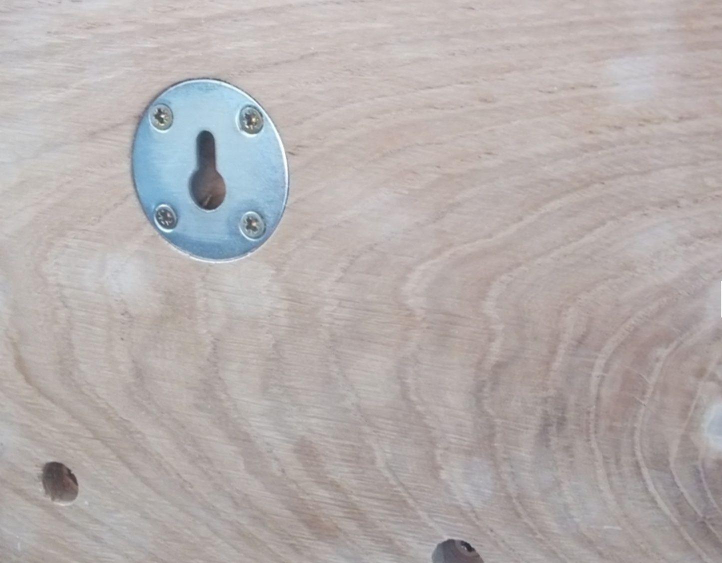 Metal keyhole on a wooden surface