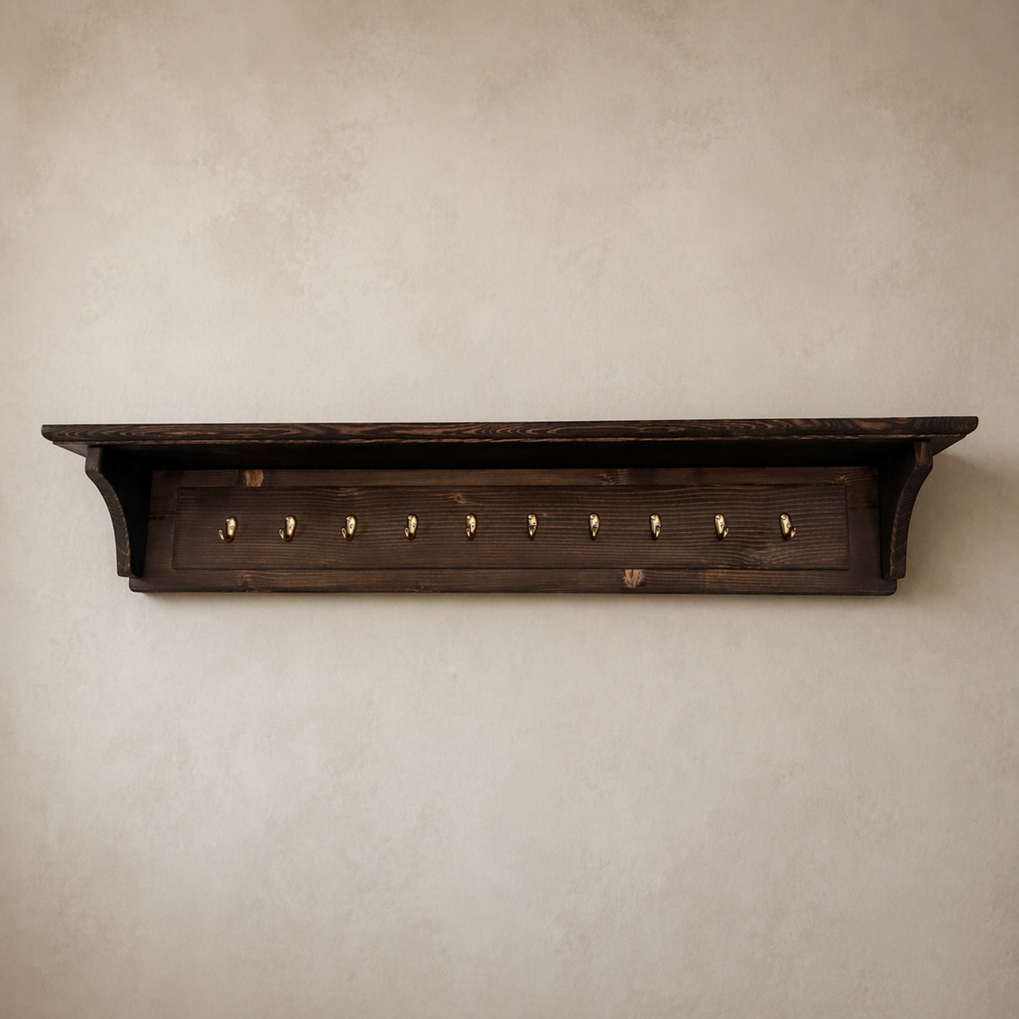 Wooden shelf with hooks on a beige wall