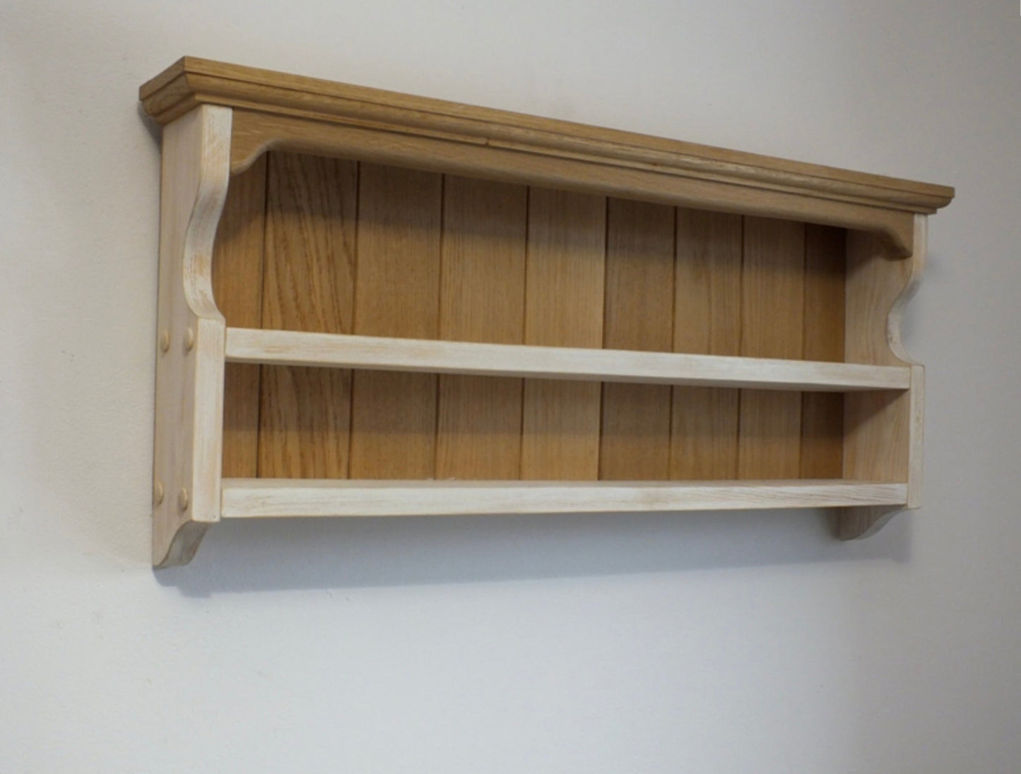 Wooden shelf mounted on a plain wall