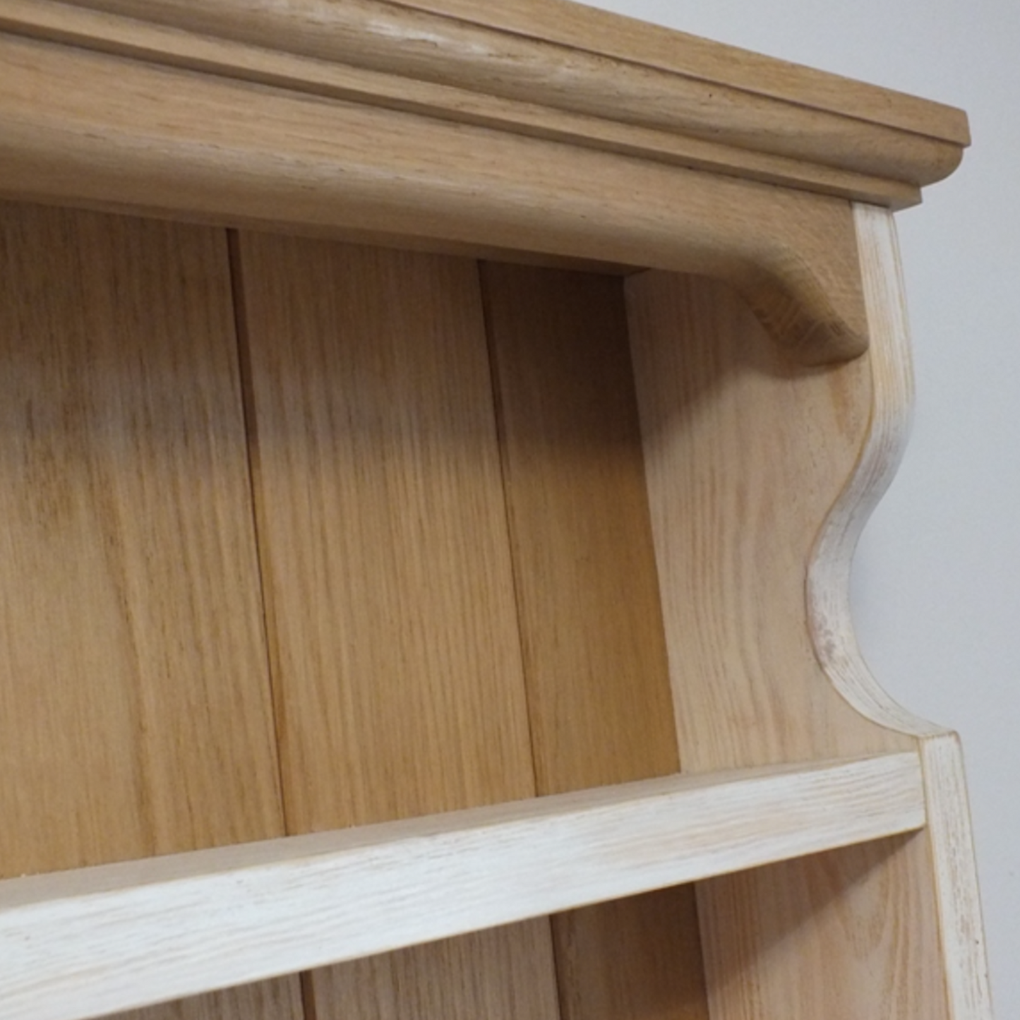 Wooden shelf with a curved design on a plain background