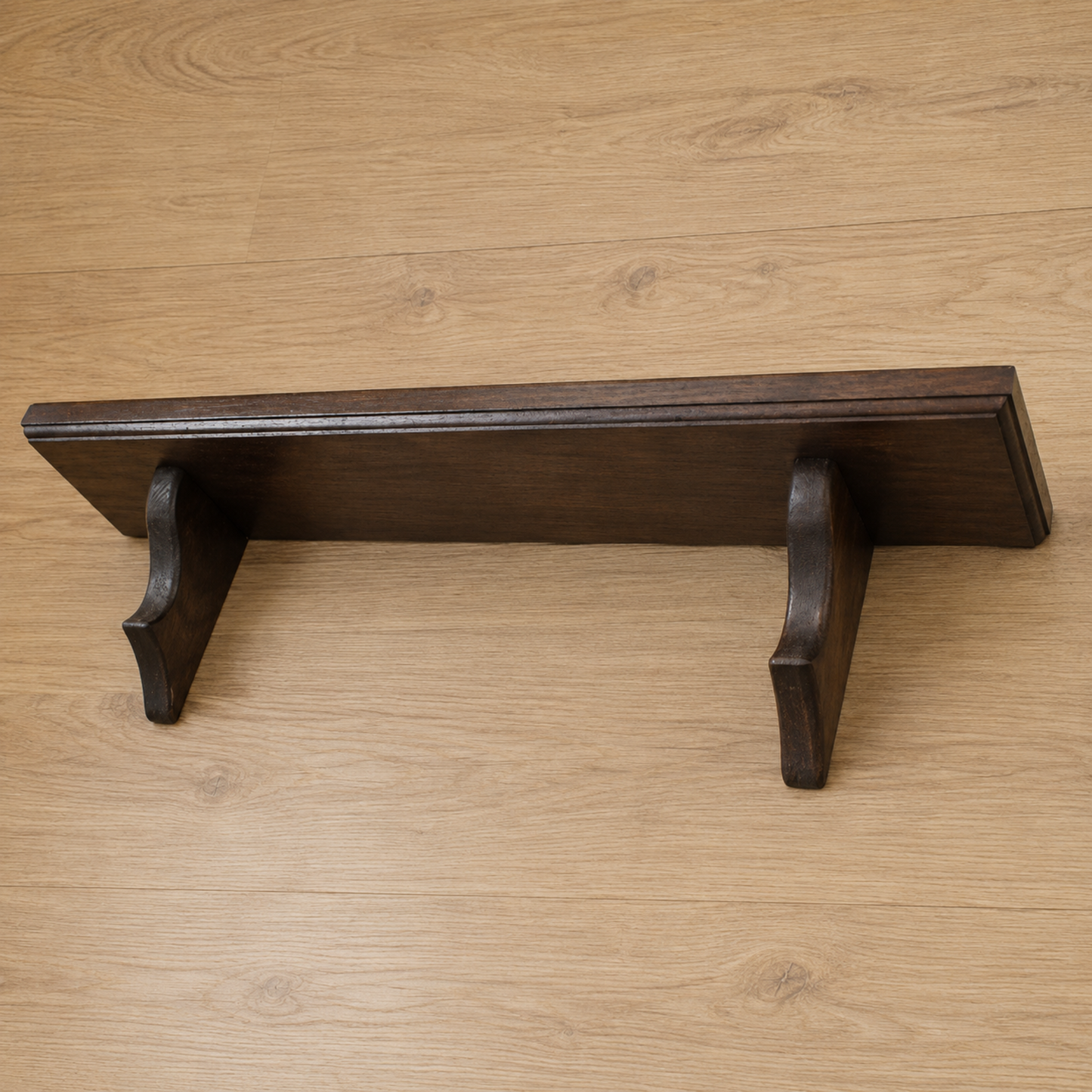 Wooden shelf with metal brackets on a wooden surface