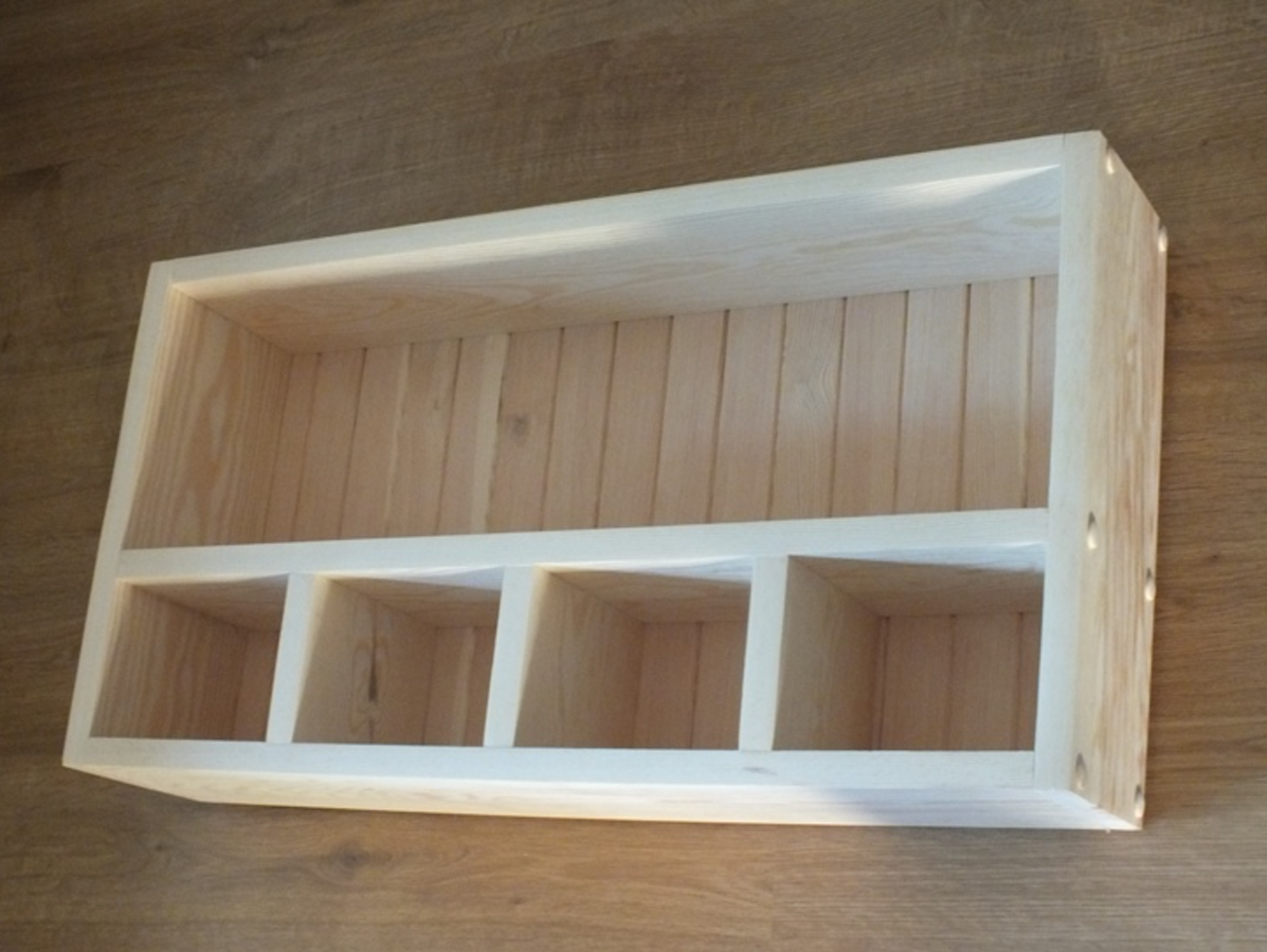 Wooden box with slotted design on a wooden surface