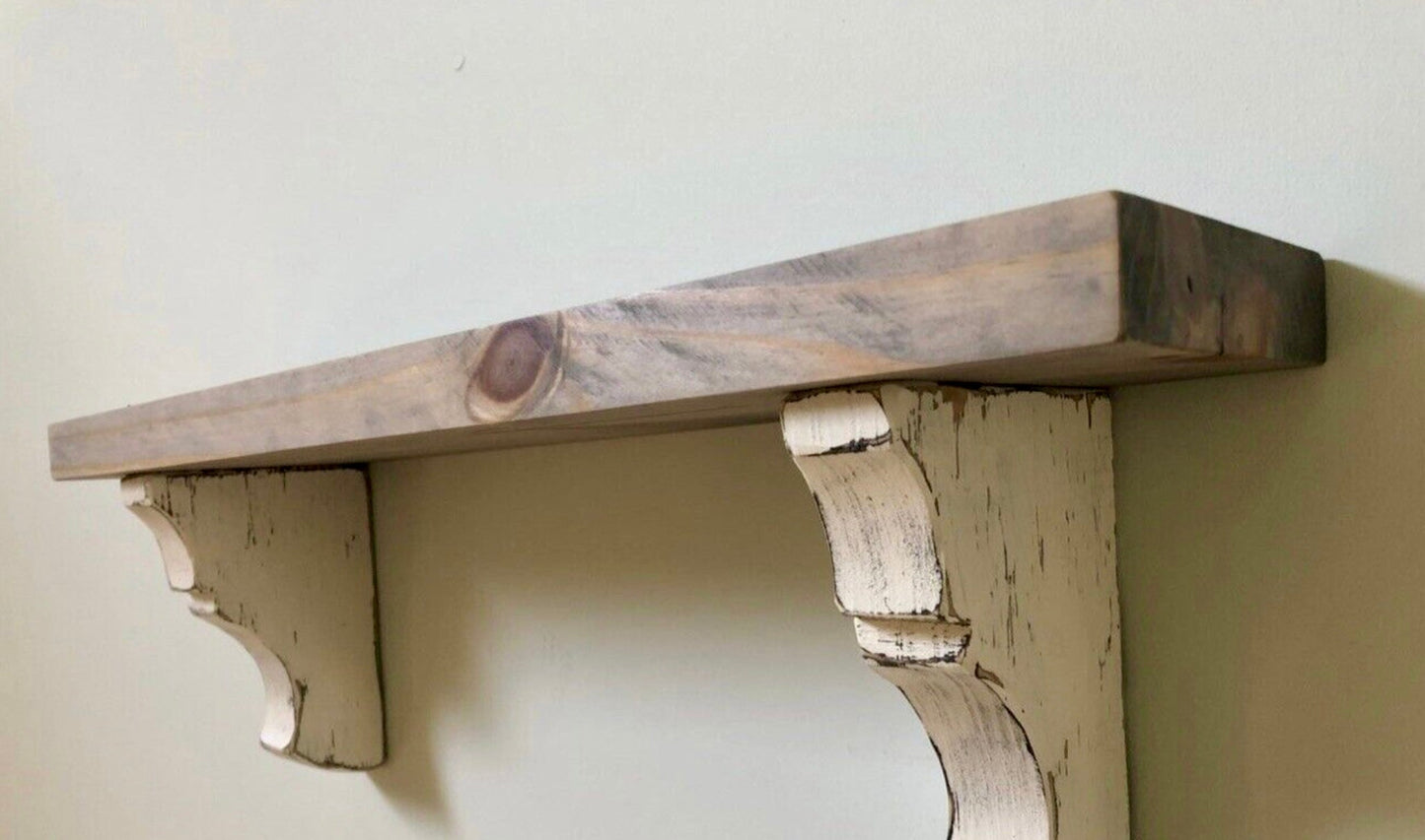 Wooden shelf with corbels against a plain wall