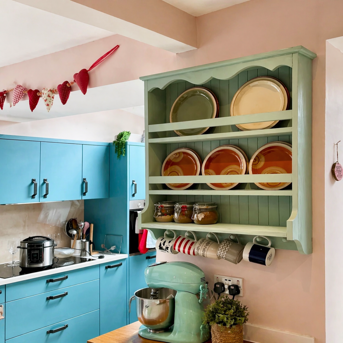 Colorful kitchen with blue cabinets, green shelves, and a mixer.