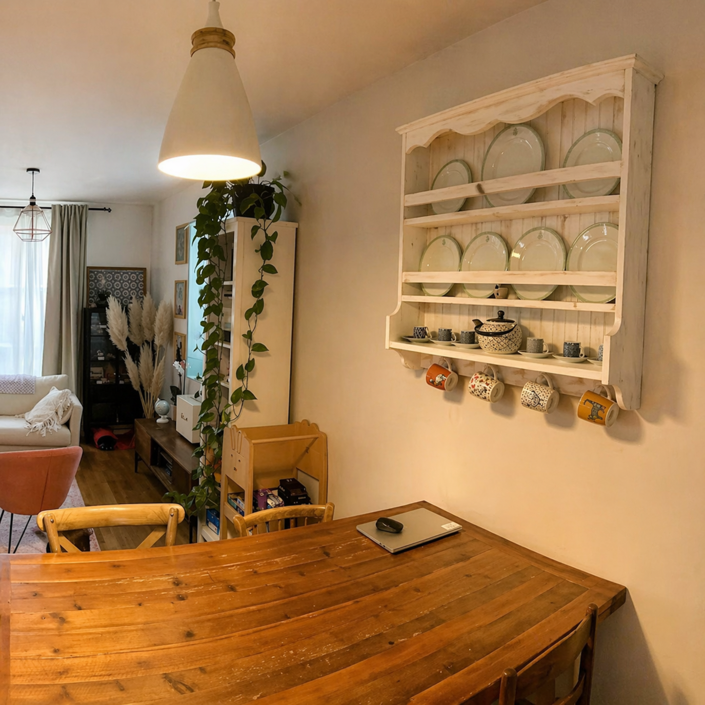 Dining room with wooden table, wall-mounted plate rack, and decor items.