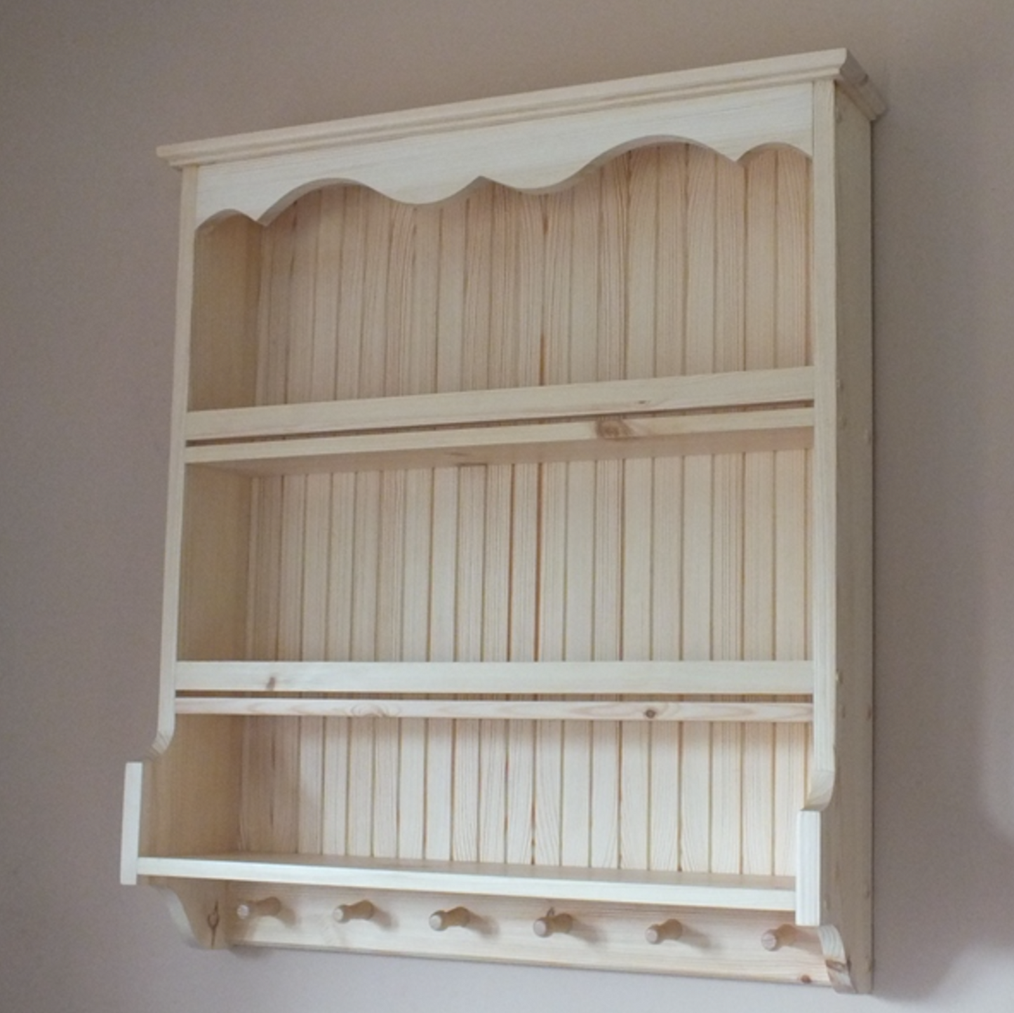 Wooden wall shelf with slatted design on a plain wall