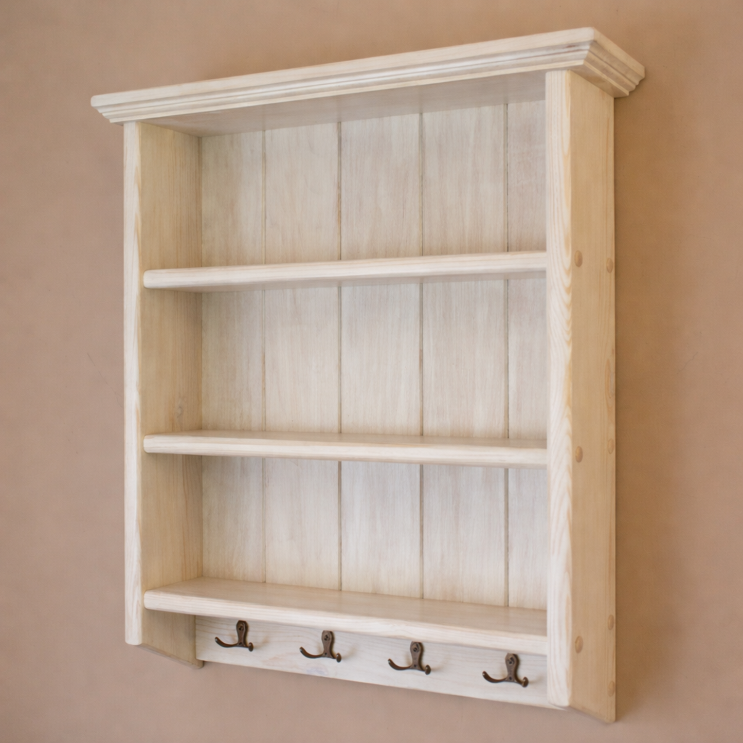 Wooden shelf with hooks on a beige wall