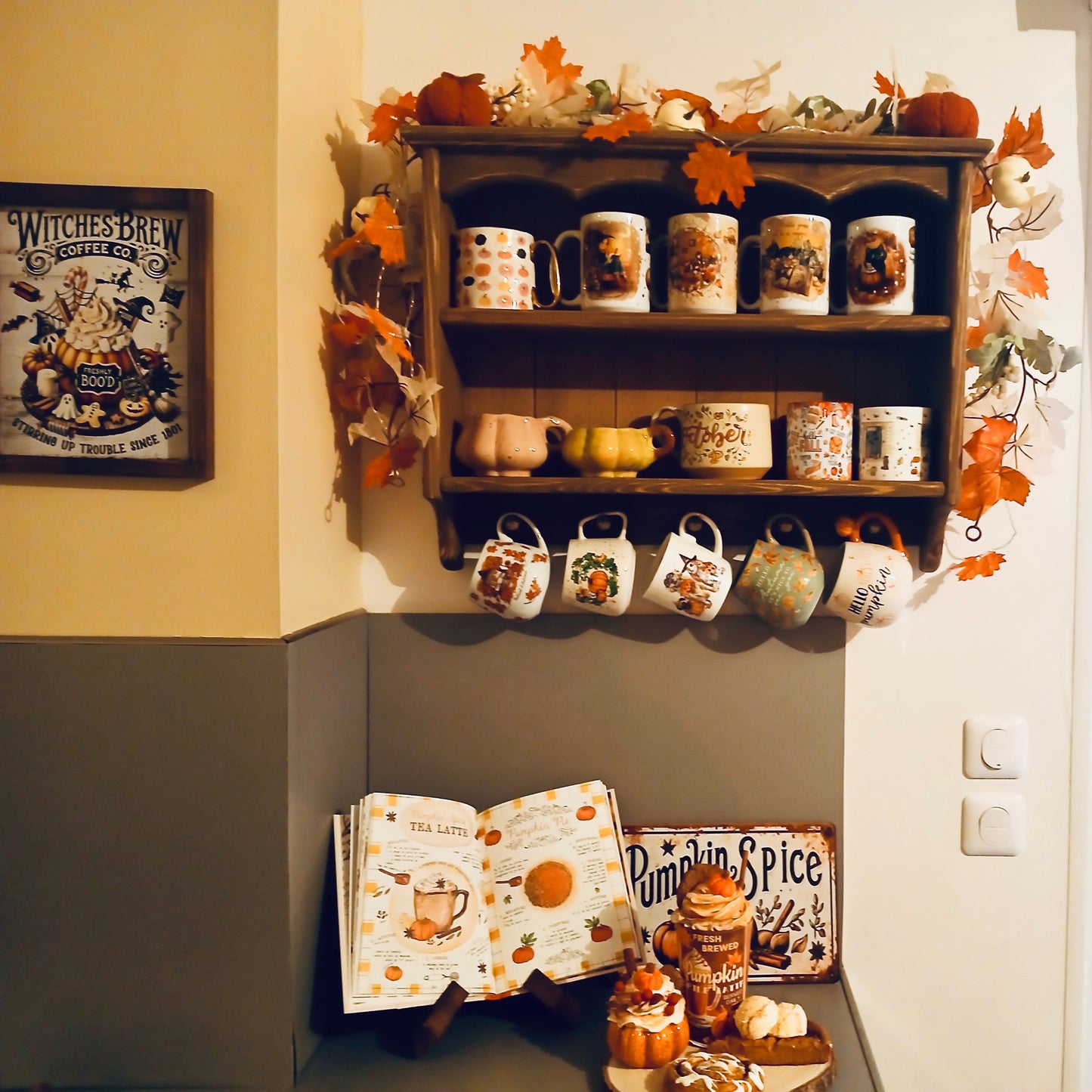 Shelf with decorative mugs and pumpkins in a room with a window and wall decor.