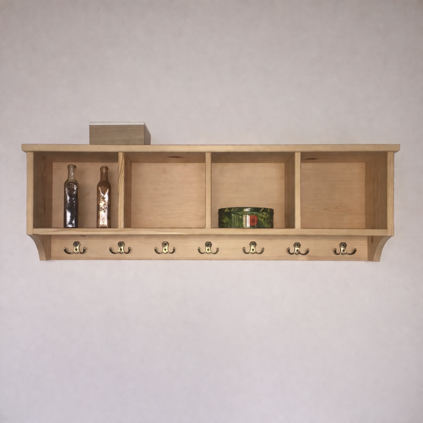Wooden shelf with hooks against a plain wall