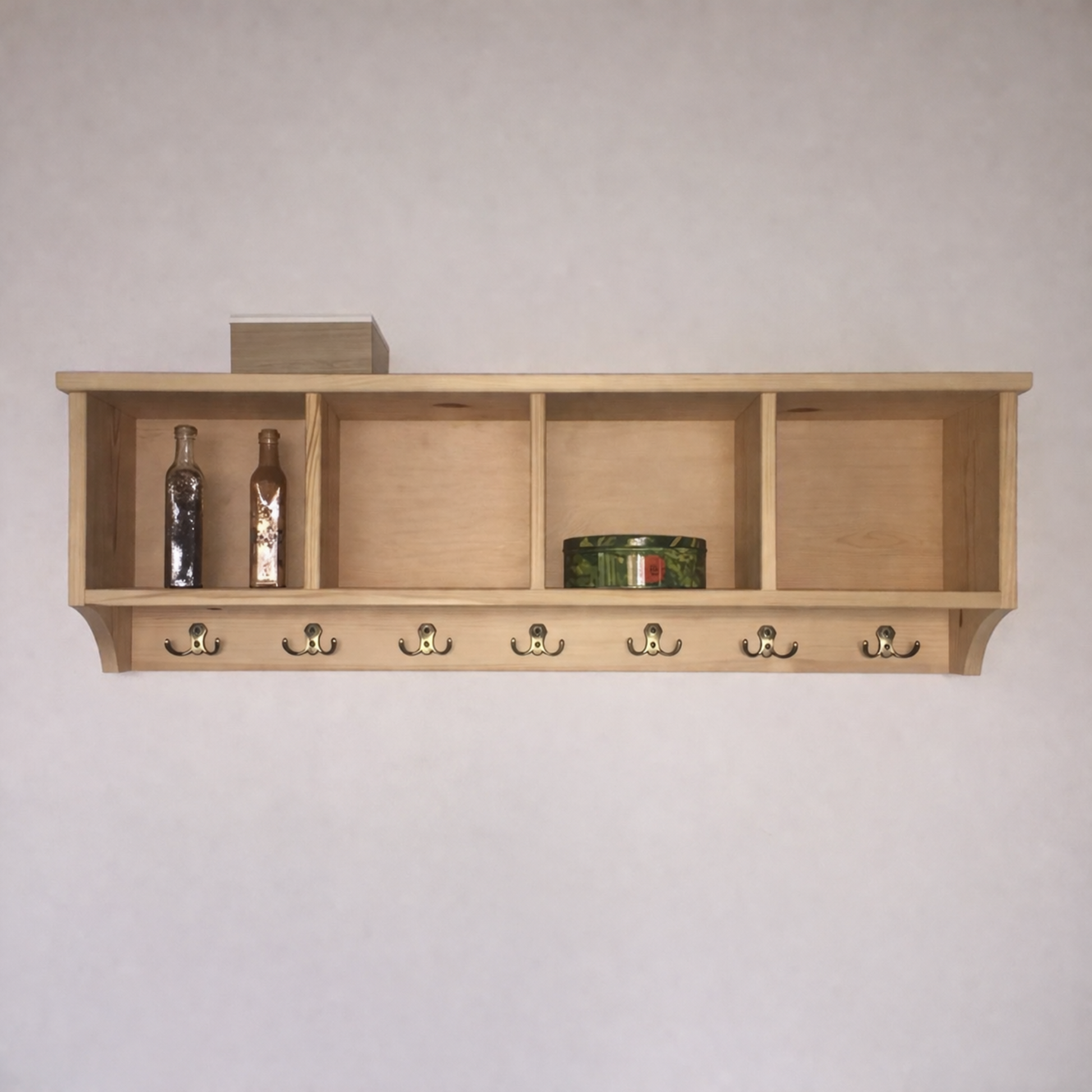 Wooden shelf with hooks against a plain wall