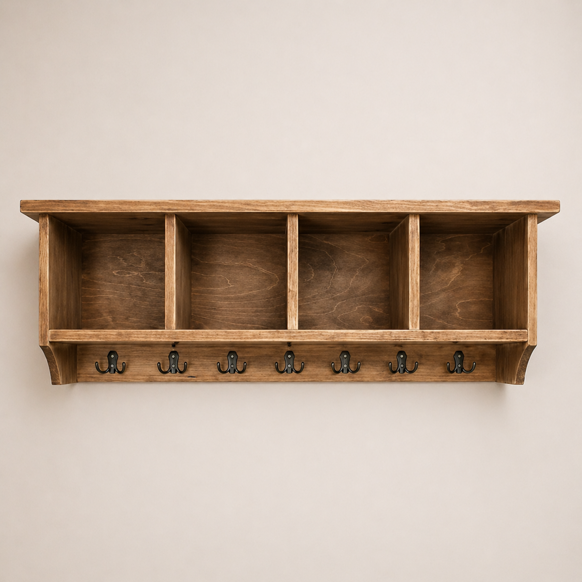 Wooden shelf with four hooks on a beige wall