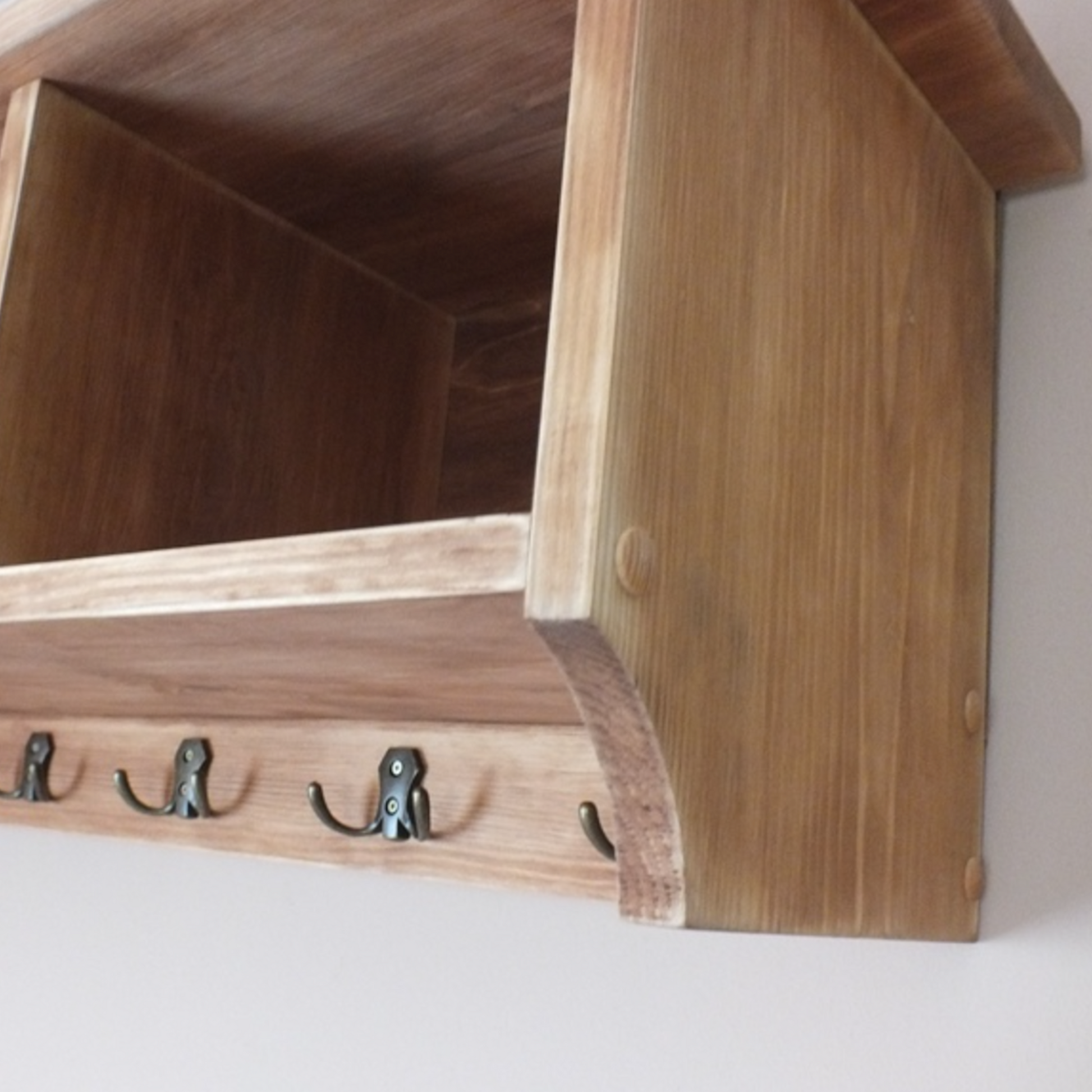 Wooden shelf with hooks on a white background