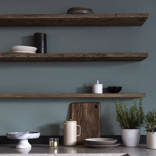 Wooden shelves with kitchen items against a teal wall