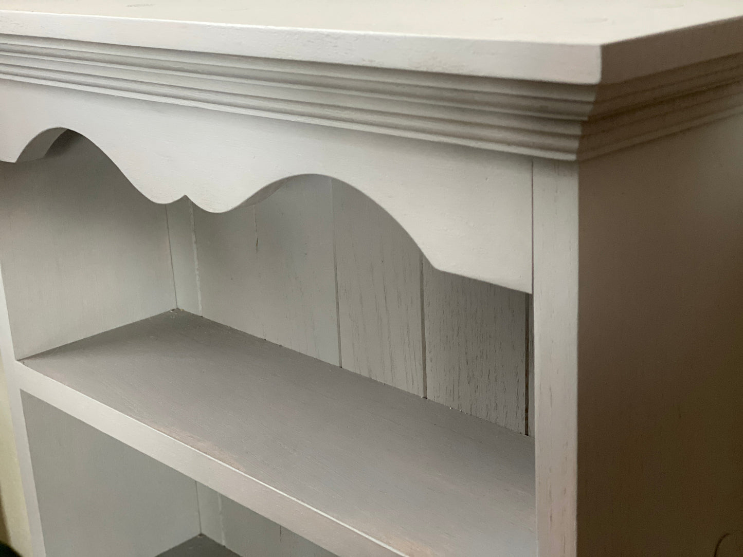 Gray wooden shelf with decorative trim