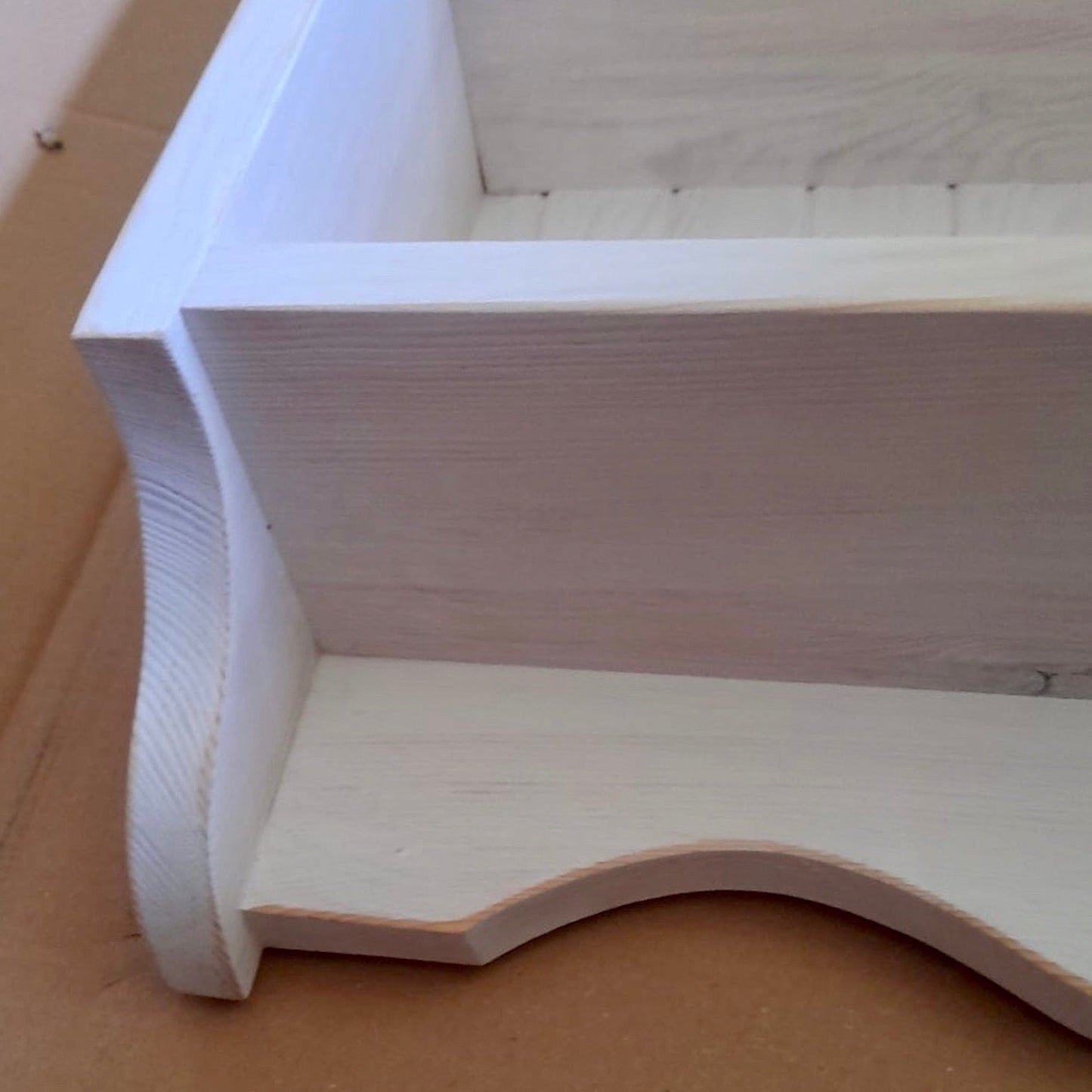 Close-up of a wooden shelf corner on a brown surface