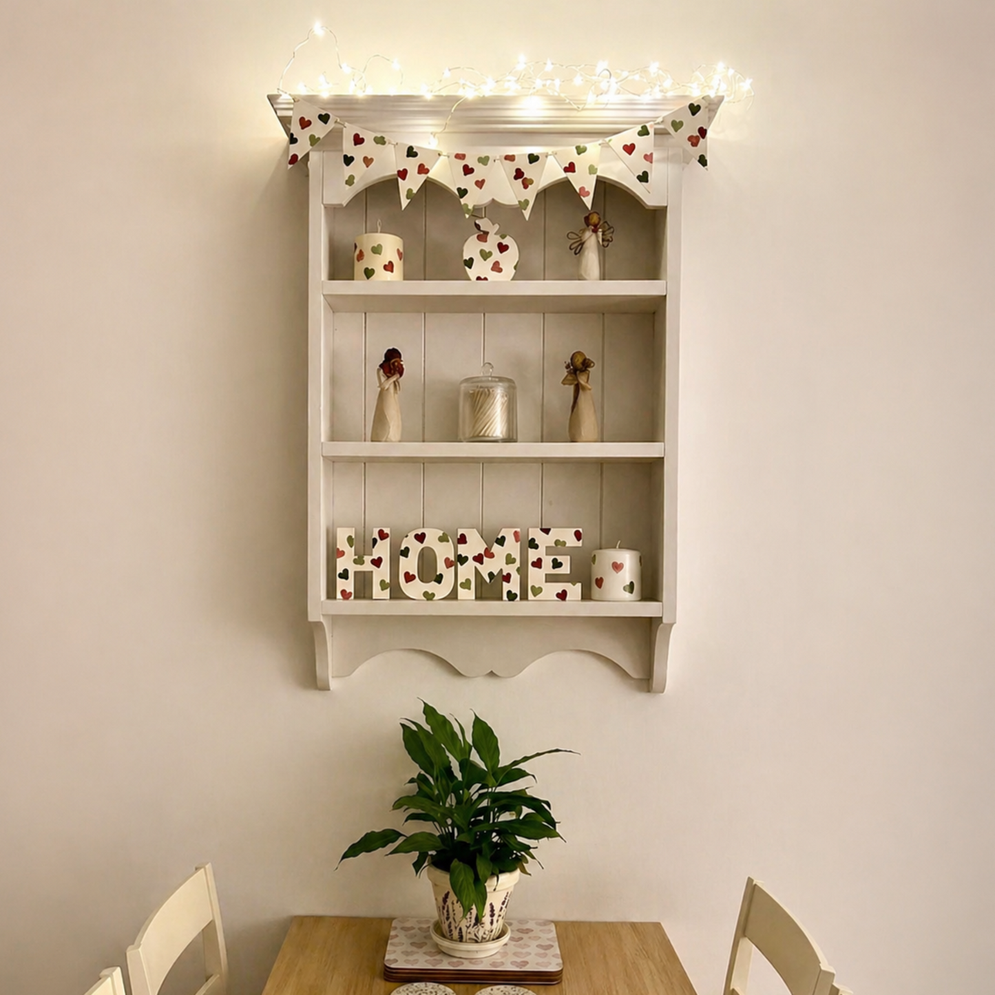 Decorative shelf with 'HOME' sign above a wooden table with a plant and coasters.