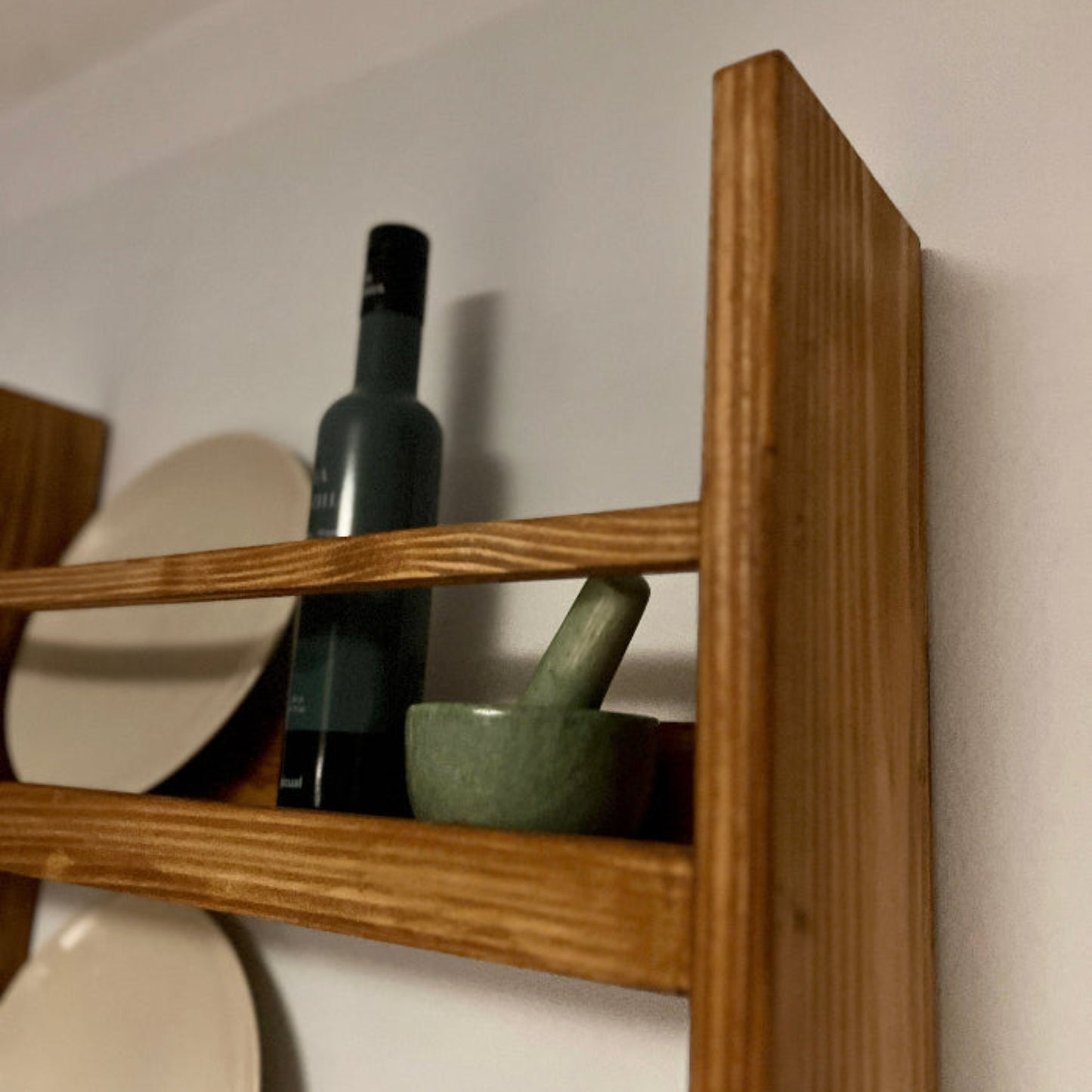 Wooden shelf with decorative items against a white wall