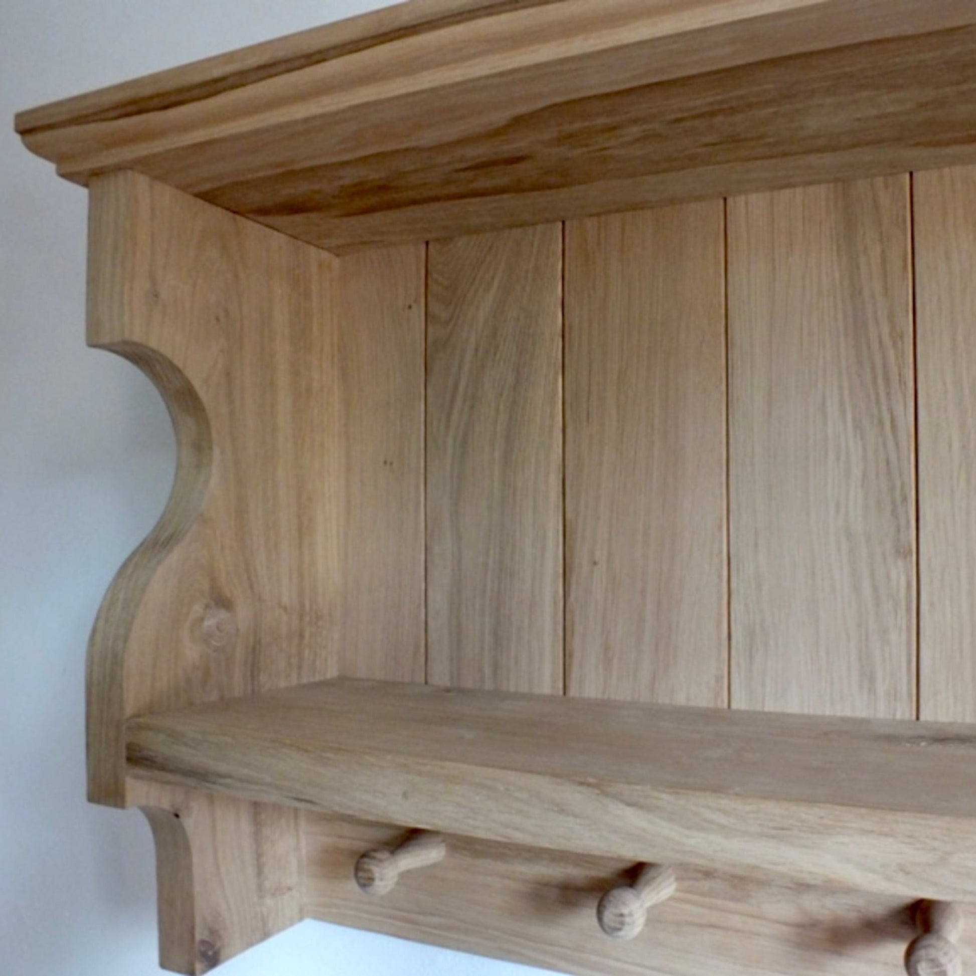 Wooden shelf with hooks on a white background