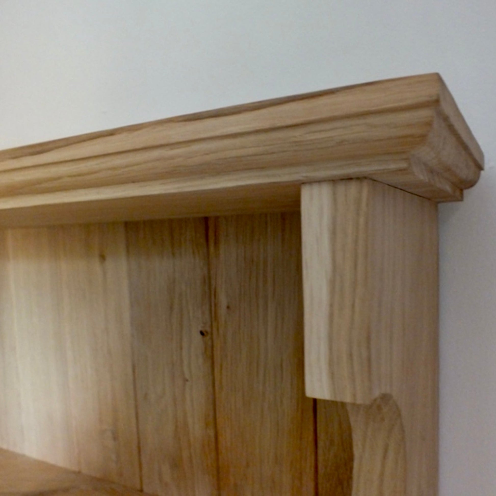 Wooden shelf against a white wall