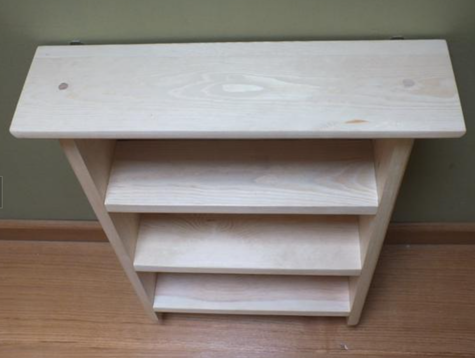 Plain wooden shelf against a neutral wall