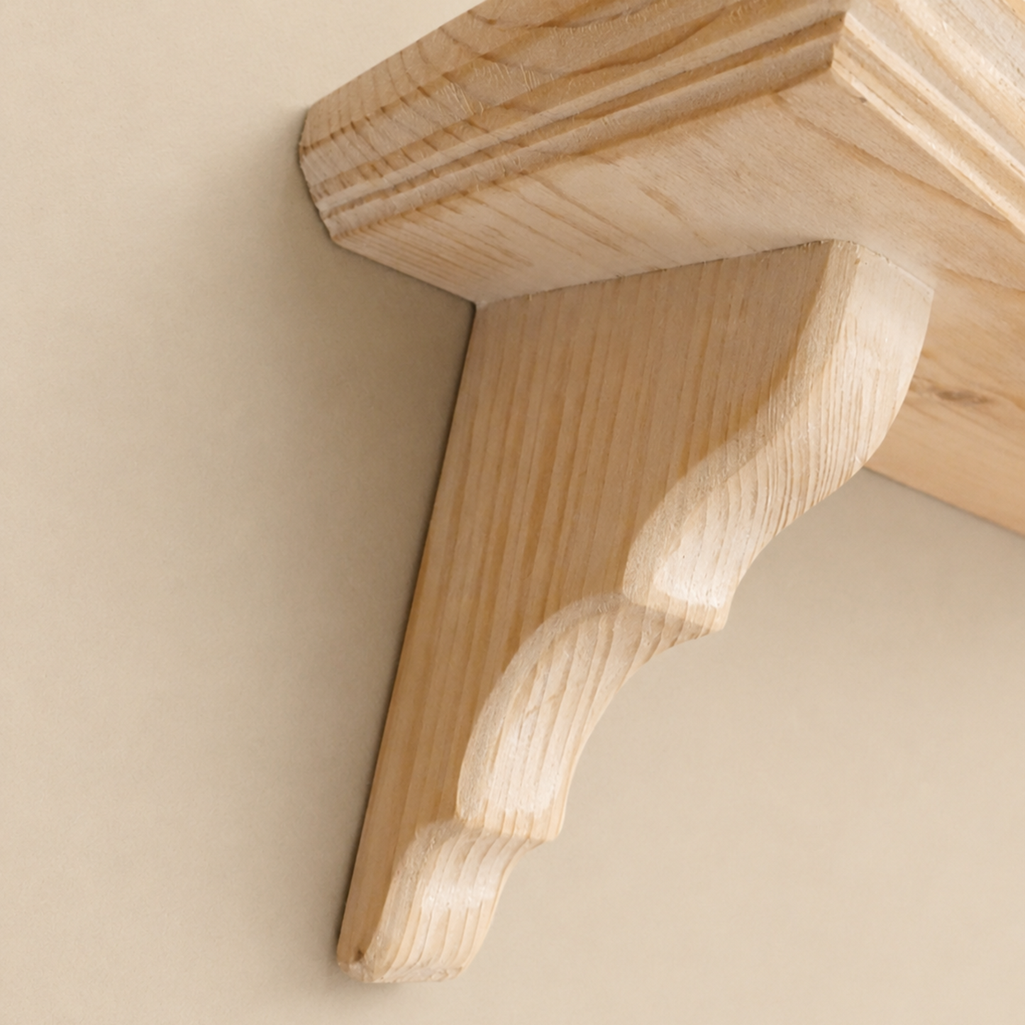Wooden shelf bracket against a beige wall