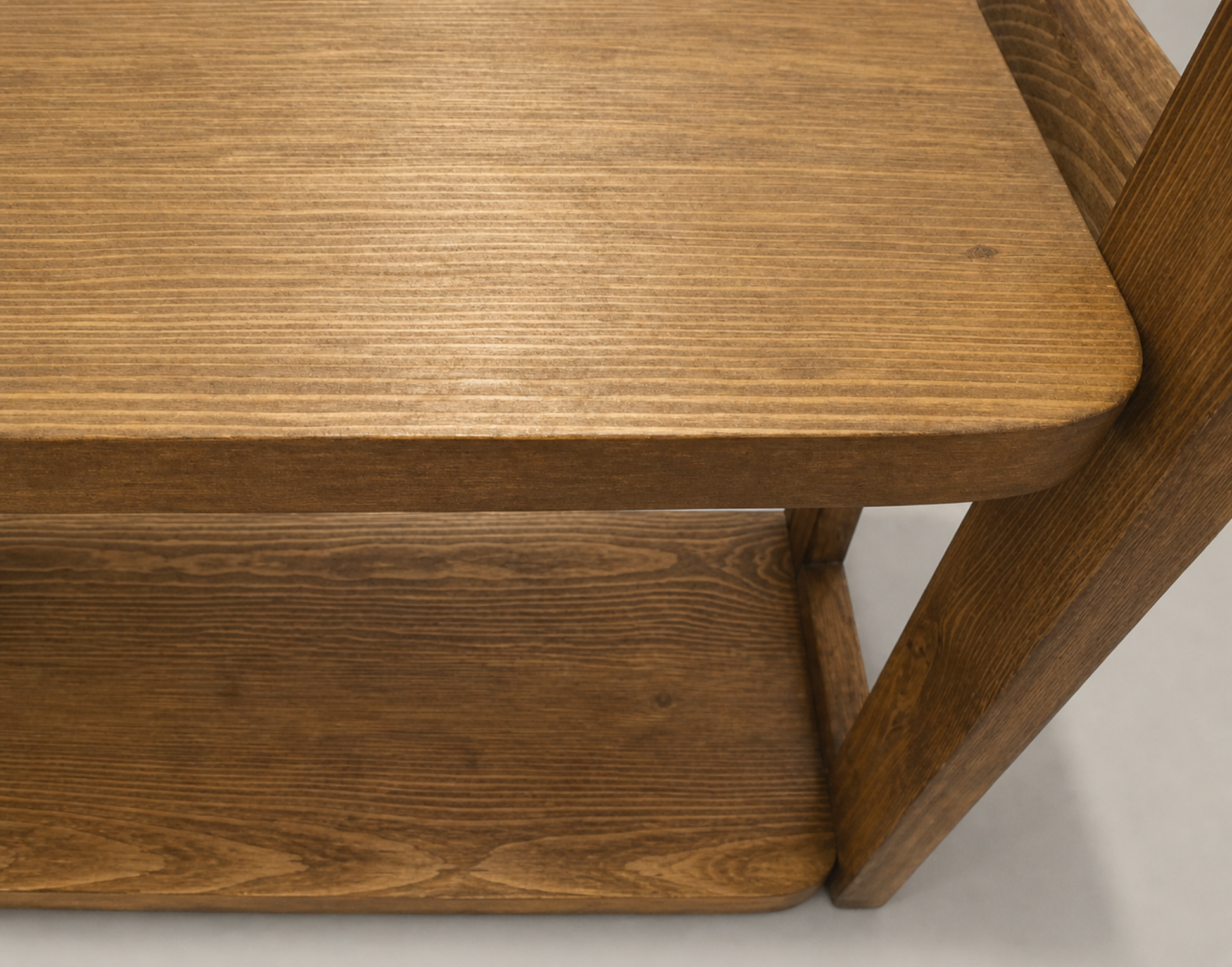 Close-up of a wooden table corner with a neutral background