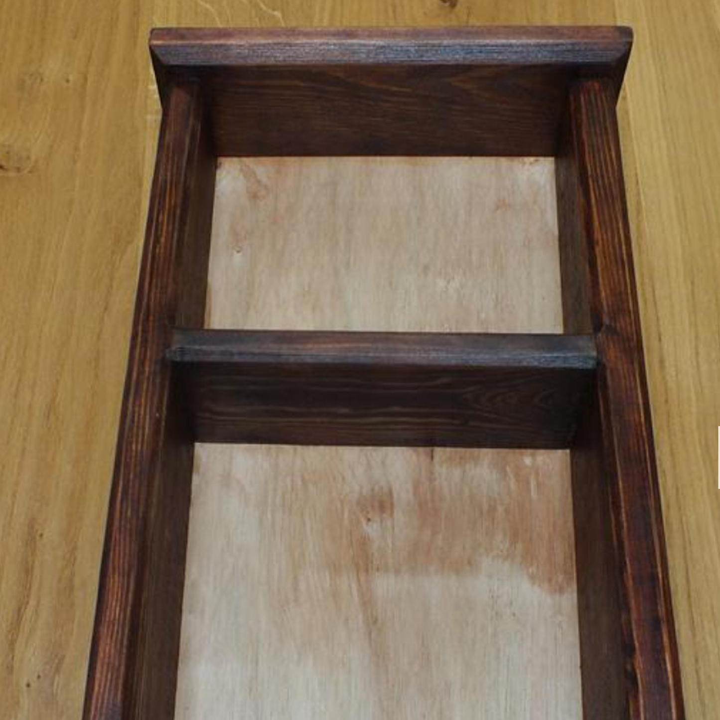 Wooden frame with a light wooden interior on a wooden surface