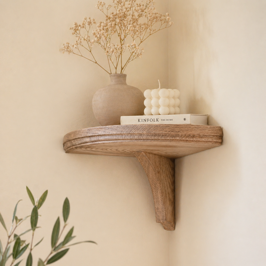 Wooden shelf with decorative items against a beige wall