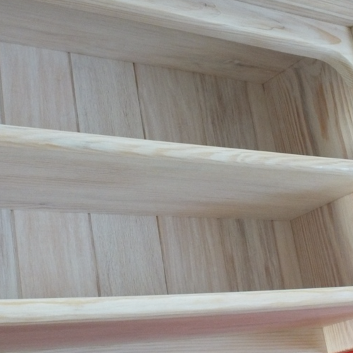 Wooden shelf with a red background