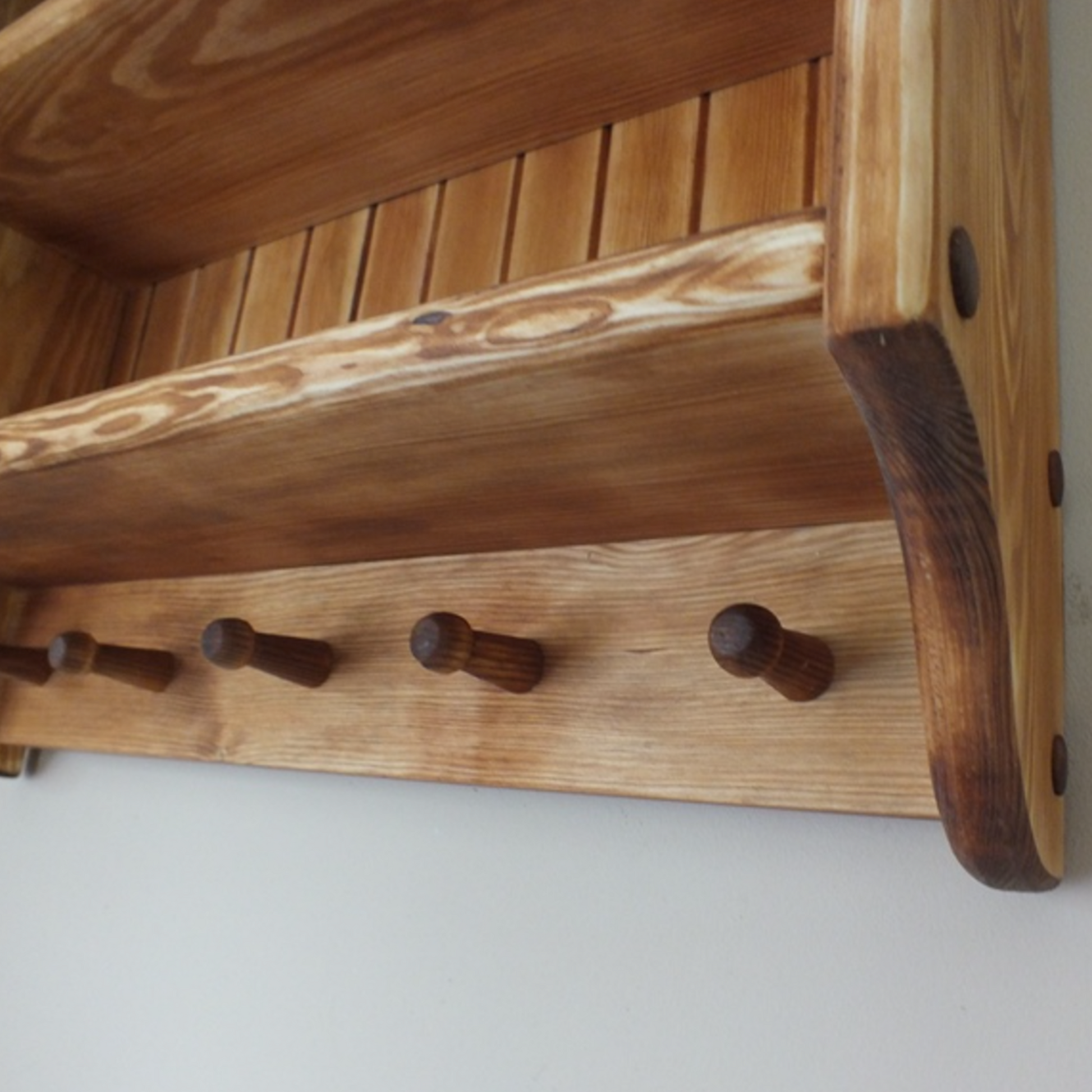 Wooden coat rack with hooks on a white background