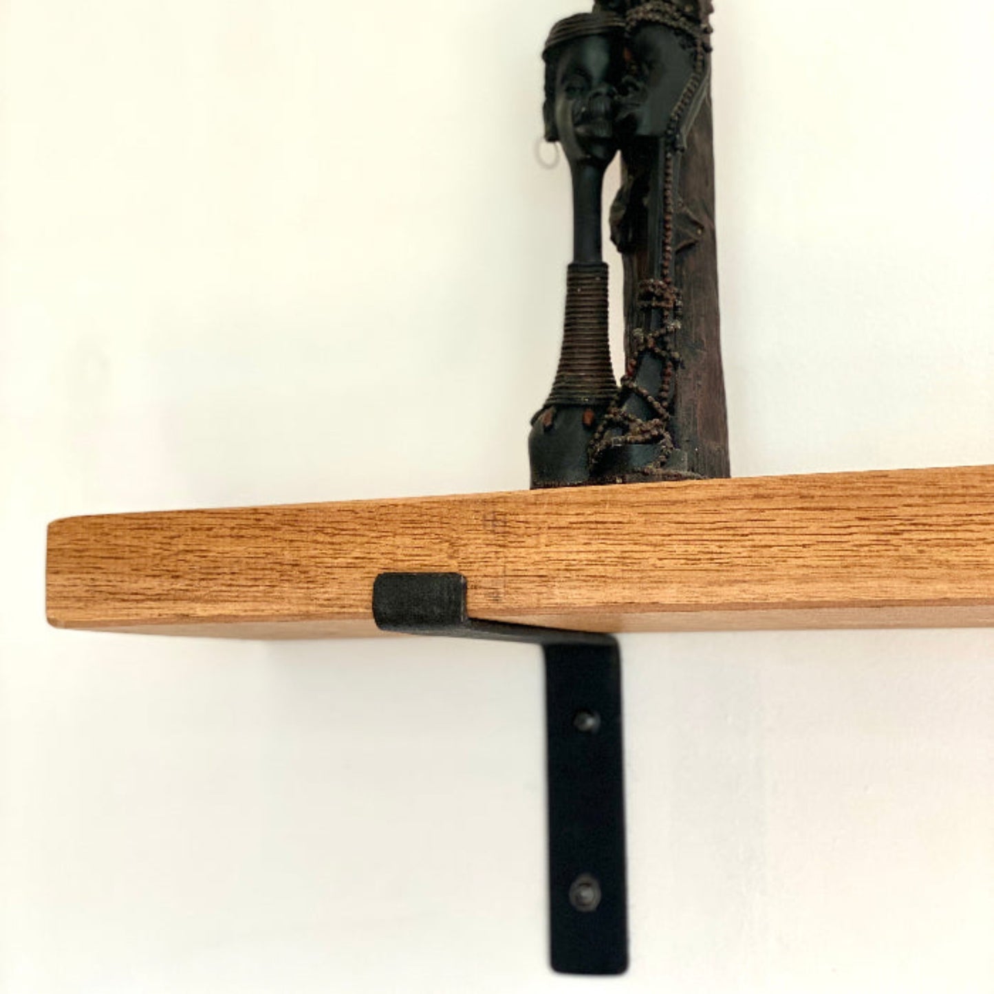 Wooden shelf with black metal bracket on a white background